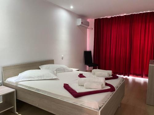 a bedroom with a large bed with a red curtain at Vila Ana Trident Costinesti in Costinesti