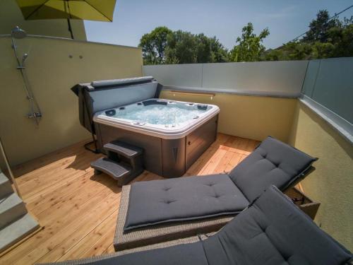 a hot tub sitting on top of a balcony at Holiday Home Tos in Risika