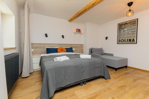 a bedroom with a large bed and a couch at Hostel Szczelinka in Pasterka