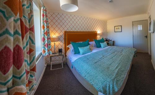 a bedroom with a large bed with blue pillows at The Hawk Inn in Andover
