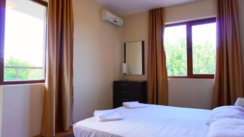 a bedroom with two beds and two windows at Апартамент Сънрайз Обзор - Apartment Sunrise Obzor in Obzor