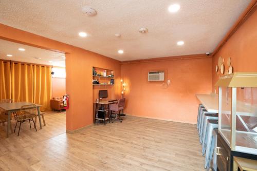 a room with orange walls and a table and chairs at Bungalows Hostel in Las Vegas