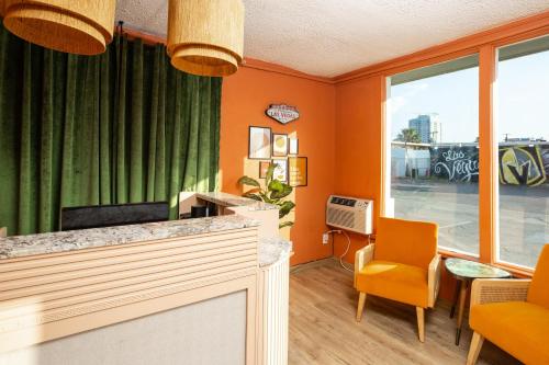 ein Büro mit orangefarbenen Wänden und orangefarbenen Stühlen in der Unterkunft Bungalows Hostel in Las Vegas