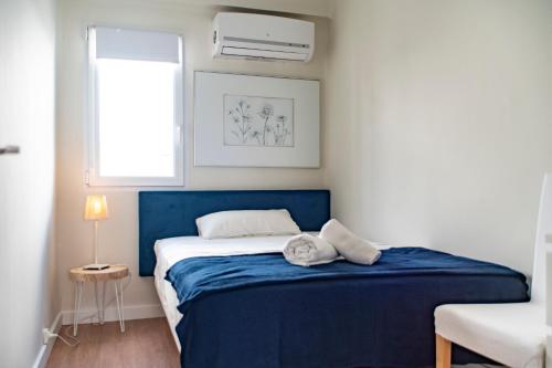 バレンシアにあるTTdSSa VLC Plaza Cisnerosのベッドルーム(青いベッド1台、窓付)