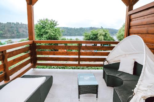 a porch with chairs and a table and a view at Chaty a Apartmány Hracholusky Kemp Kosatka in Pňovany