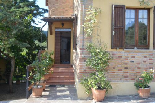 a brick house with potted plants in front of it at Villa Mischianti in Gubbio