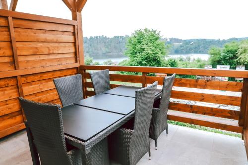 a table and chairs on a deck with a view at Chaty a Apartmány Hracholusky Kemp Kosatka in Pňovany