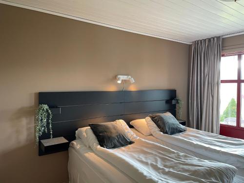 a bedroom with two beds and a headboard at Høiland Gard Gardshotellet in Årdal