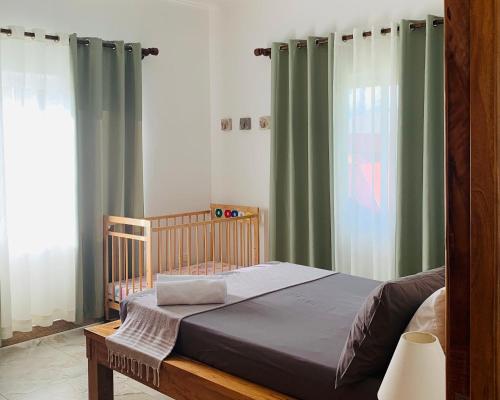 a bedroom with a bed with green curtains at Chez Coco in Pointe Au Sel 