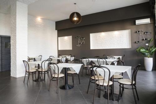 a dining room with white tables and chairs at Affittacamere Villa Bisceglia in Monte SantʼAngelo
