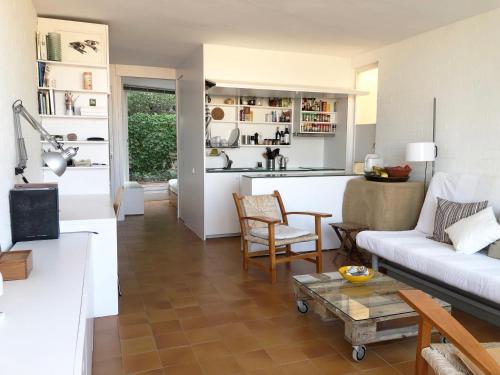 a living room with a couch and a kitchen at Apartamento con vistas al mar in Cadaqués