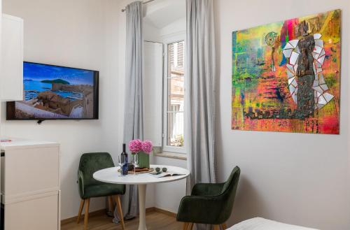 ein Zimmer mit einem Tisch und einem Gemälde an der Wand in der Unterkunft GAMA Dubrovnik 1 in Dubrovnik