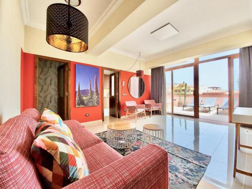 - un salon avec un canapé rouge et une table dans l'établissement AROMAS Suites Attic, à Puerto de la Cruz