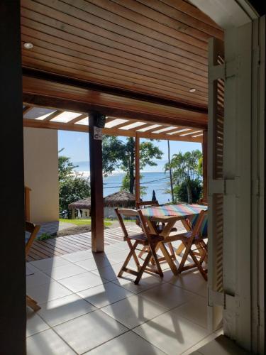 un patio con tavolo, sedie e vista sull'oceano di La Bella Suítes a Ilhabela