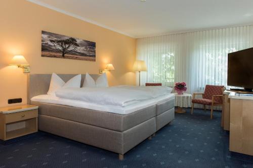um quarto de hotel com uma cama e uma televisão em Hotel Restaurant Zum Schiffchen em Maintal