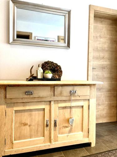 a wooden cabinet with a mirror on a wall at Haus Bazigg in Klösterle am Arlberg