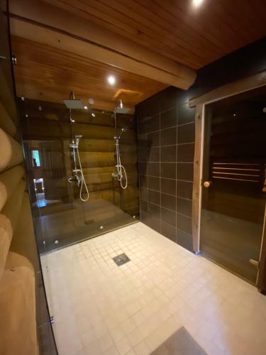een badkamer met een douche en een tegelvloer bij Laane Talu Sauna House in Uhtjärve