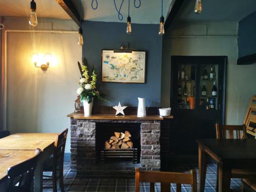 a fireplace in a restaurant with a table and chairs at The Malthouse in Halifax