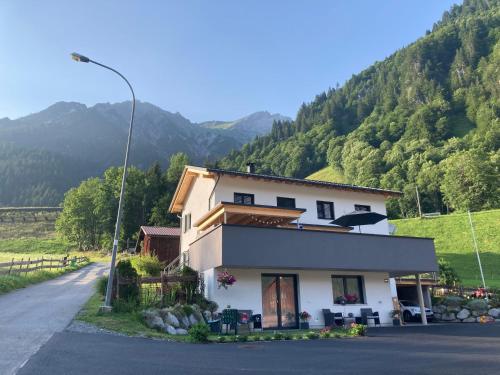 a white house on the side of a road at Haus Bazigg in Klösterle am Arlberg