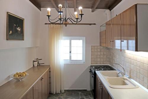 a kitchen with a chandelier above a sink and a stove at Cretan Country house in Áyios Spirídhon