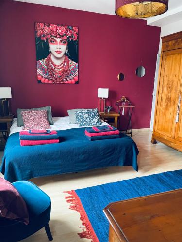 une chambre avec un lit avec un tableau sur le mur dans l'établissement Villa des Roses, à Pontmain