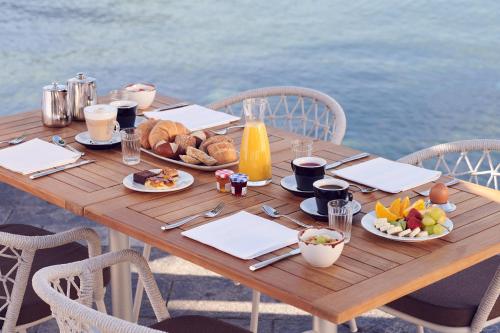 a wooden table with breakfast foods on it at Al Faro in Ascona