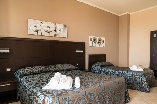 a hotel room with two beds with white shoes on them at Affittacamere Villa Bisceglia in Monte SantʼAngelo