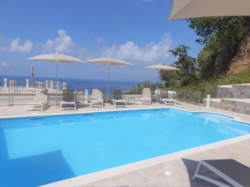 a swimming pool with chairs and umbrellas at Appartamenti Borgo Panoramico N 9 in Tropea