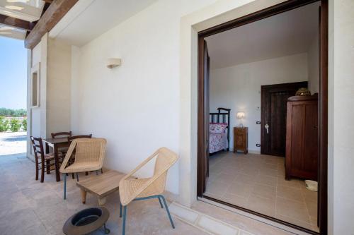 a room with a table and chairs and a mirror at TERRA TERRA - Masseria Minunni in Conversano