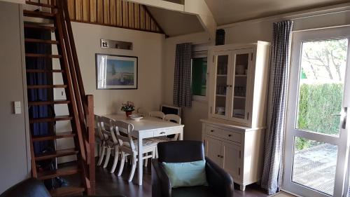 une salle à manger avec une table et des chaises et une fenêtre dans l'établissement COTTAGE - Lac du Causse, à Chasteaux