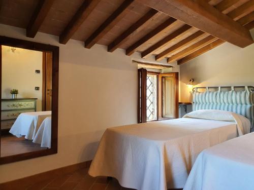 a bedroom with two beds and a mirror at Agriturismo Cardella in Piobbico
