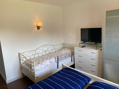 1 dormitorio pequeño con 1 cama y TV en Ferienwohnung Nina Lütjenburg Klamp Ostsee, en Lütjenburg