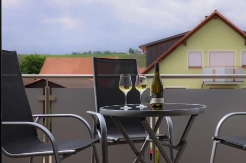 twee glazen wijn op een tafel op een balkon bij Ferienwohnung Volkacher Str.10 in Nordheim