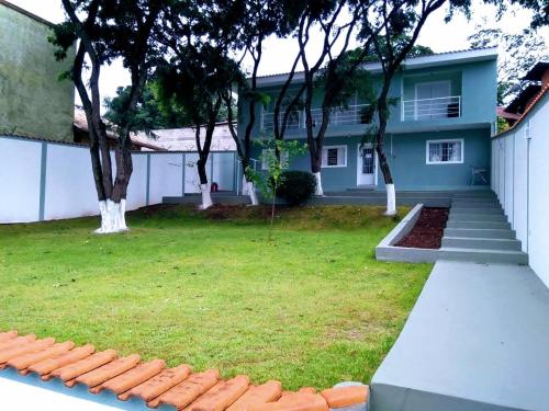 a house with a green yard with trees in it at Flat Pé de Mamão in Campinas