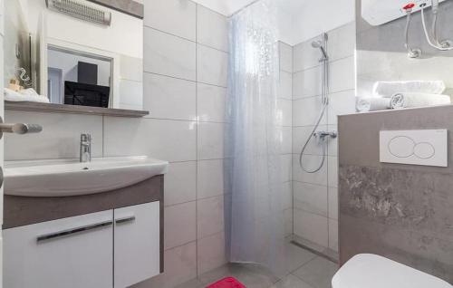 Apartment Betty في بارباريغا: حمام أبيض مع حوض ودش