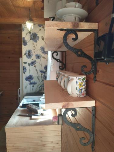 um quarto com prateleiras de madeira e uma mesa com uma vela em Chabrowa Chatka em Supraśl
