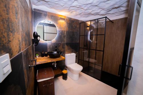 a bathroom with a toilet and a sink and a mirror at Casa Rural Las Colmenas in Alcalá del Júcar