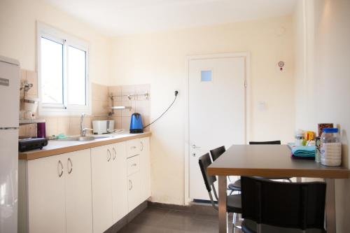 a kitchen with a table and a window and a door at Neve Tzedek Original Style Apartments in Tel Aviv