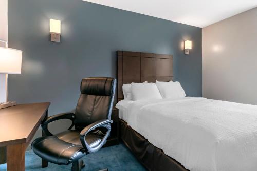 um quarto de hotel com uma cama, uma secretária e uma cadeira em Econo Lodge em Montreal