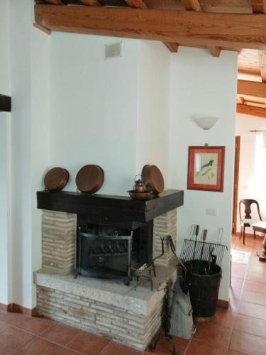 a living room with a fireplace with hats on top at Agriturismo Il Casaletto in Montefranco