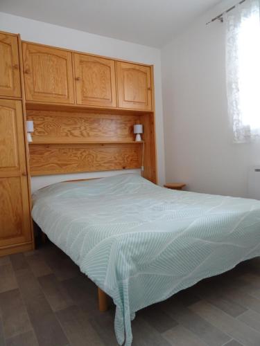 un lit avec une tête de lit en bois dans une chambre dans l'établissement Le cocon de Garrigou, à Luchon