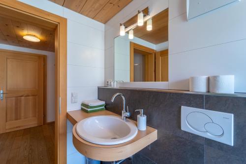 a bathroom with a sink and a mirror at Ferienbauernhof Berlinger in Au im Bregenzerwald