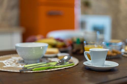 a table with two cups and plates and utensils at Dimora Le Site in Torre Suda