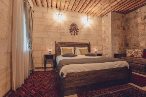 a bedroom with a large bed in a room at Vasıl Cave Hotel in Uçhisar
