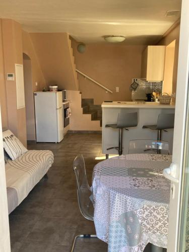 une petite chambre avec une table, une cuisine et des escaliers dans l'établissement DUPLEX 4 PERSONNES Clim Wifi Parking, à Partinello
