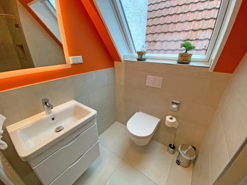 a bathroom with a sink and a toilet and a window at WIRTSHAUS am Niederntor in Blomberg