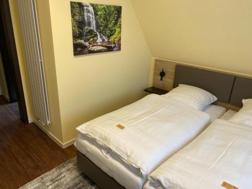 two beds in a room with a waterfall painting on the wall at WIRTSHAUS am Niederntor in Blomberg