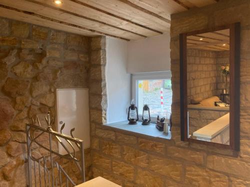 uma parede de pedra numa cozinha com um espelho em Heiderose` s em Naumburg