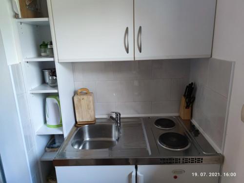 a small kitchen with a sink and white cabinets at SUMMER TIME in Premantura