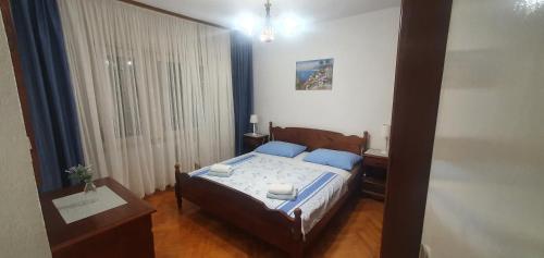 een slaapkamer met een bed met blauwe kussens bij Apartmani Matea in Trogir